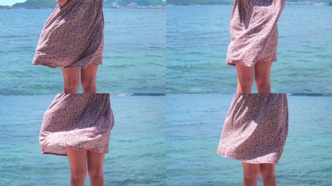 穿着裙子的年轻漂亮女人呆在码头上，风吹得很大。适合腿。运动生活方式