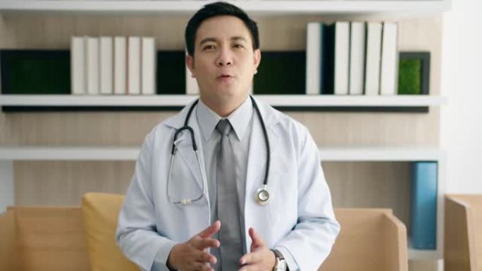 穿着白大褂的亚洲男性医生的肖像通过视频与患者在线通话咨询。通过网络摄像机在线进行医生视频会议。
