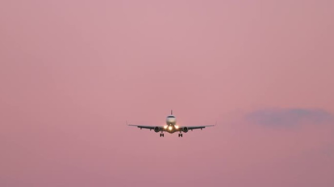 粉色日落天空背景4K上的电影慢动作前视白色飞机