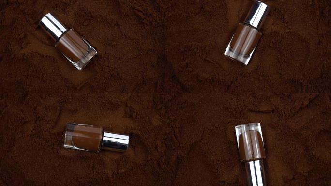 带有棕色指甲油的瓶子躺在咖啡粉的表面上