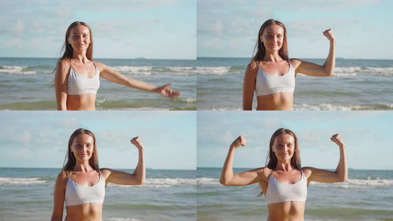 运动后的肖像运动年轻女性看着相机展示二头肌手臂。穿着运动服的白人女性肖像展示手臂肌肉。强健的身体理念