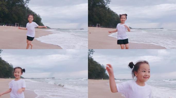 4k可爱的5岁亚洲黑发女孩在海洋海岸附近洋溢着幸福的笑容和享受，看到强烈的海浪和地平线日落，这对孩子