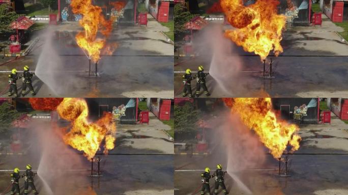 顶部和侧视图消防员团队在车站培训人员期间练习使用洒水装置扑灭现场煤气管的火