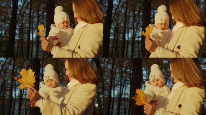 妈妈给宝宝看一片泛黄的叶子