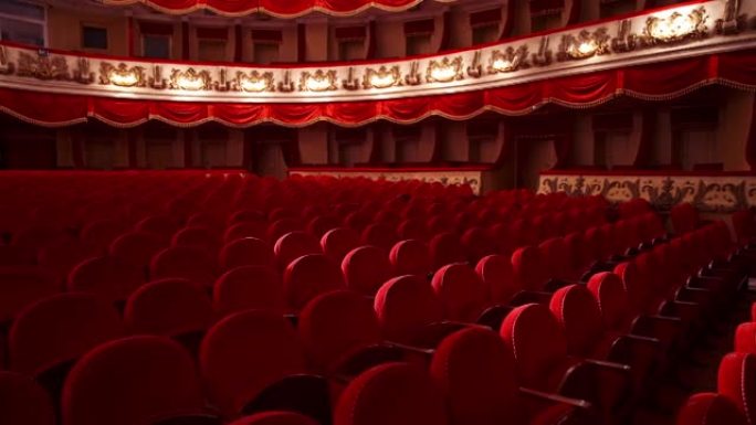 剧院里空的红色座位。没有人的大厅。没有观众观看戏剧的空椅子或沙发。活动前关闭的地方。