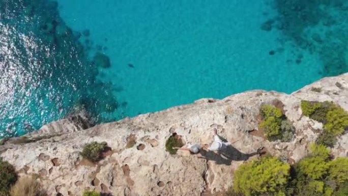 4k视频无人机视图，年轻夫妇在希腊扎金索斯悬崖周围围堵