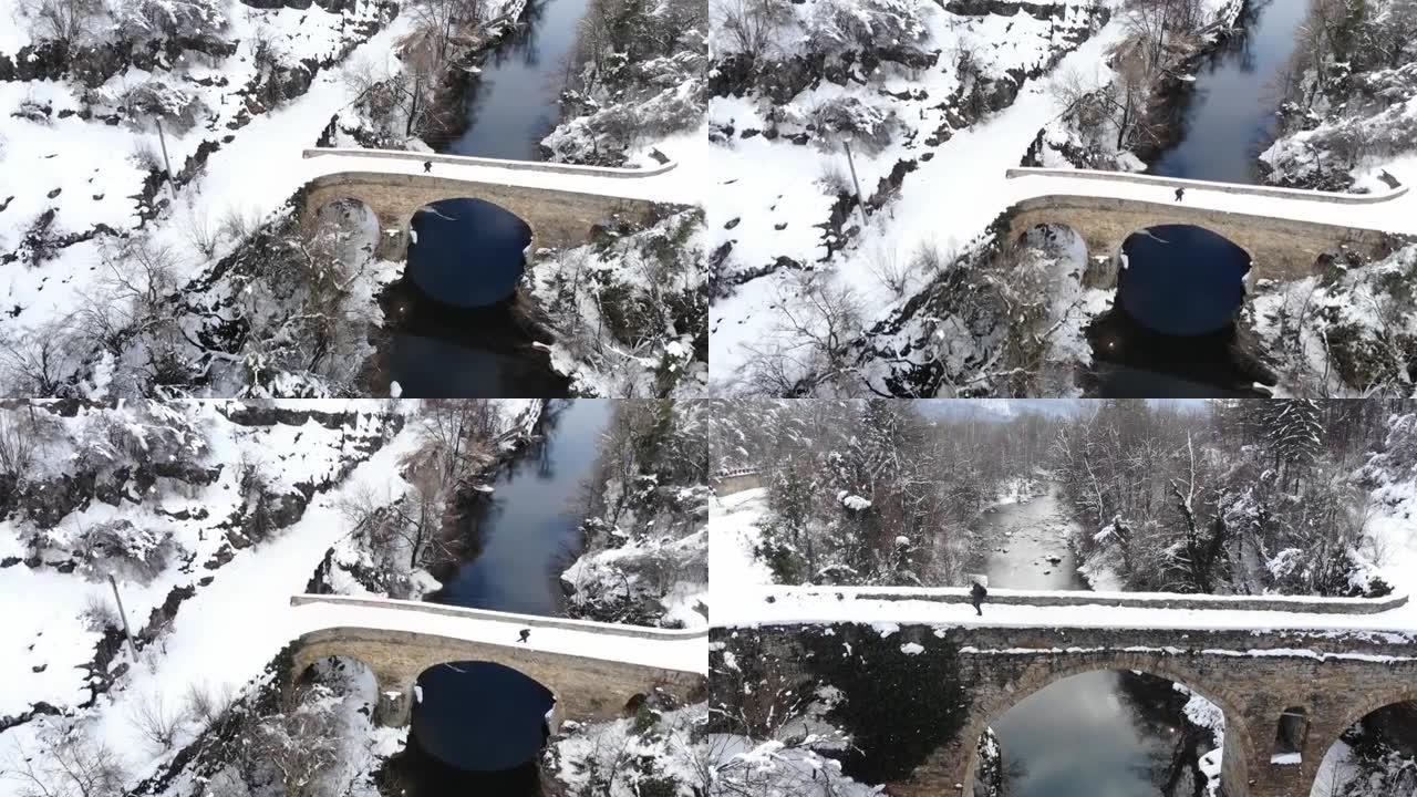 一名男性游客在冬季使用导航在历史桥上行走的4k视频