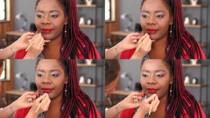 4k视频特写化妆师给一个非洲女孩专业化妆的眼睛戴上眼影