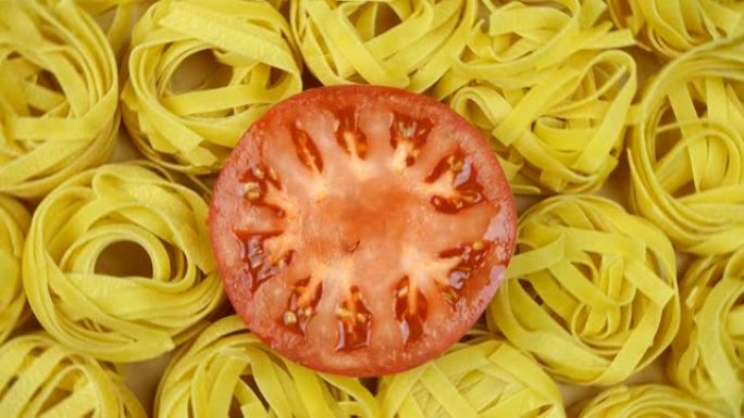 许多干意大利面，在圆心点缀有切好的番茄，顺时针旋转。