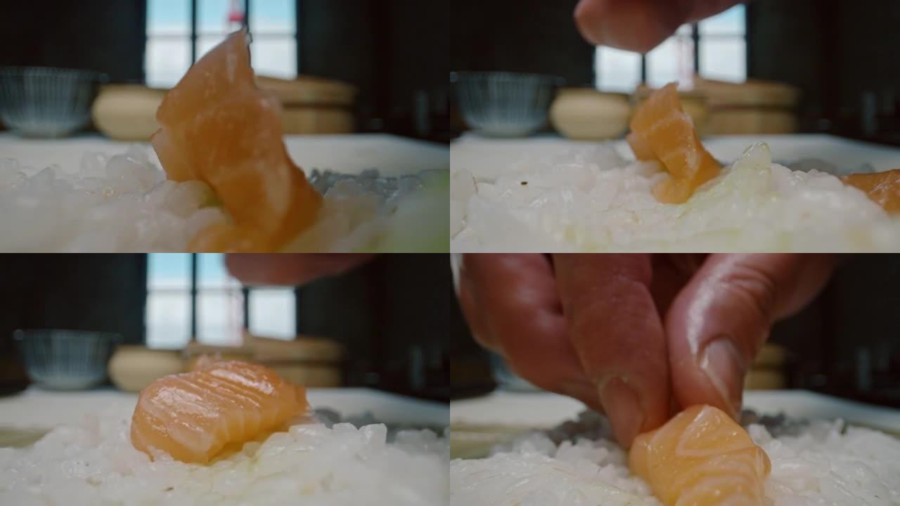 日本厨师在做寿司maki时将三文鱼放在米饭上