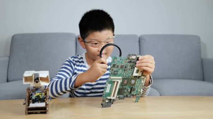 年轻的科学家正在用放大镜观察电路板