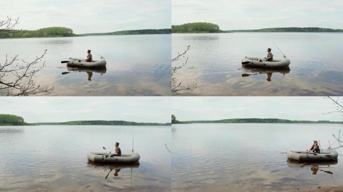 年轻的渔民在湖上的充气船上划桨。