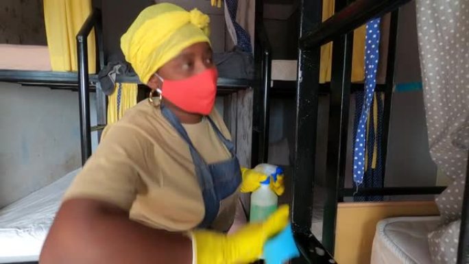 4k视频非洲妇女使用清洁海绵和酒精消毒剂喷雾在宿舍房间清洁