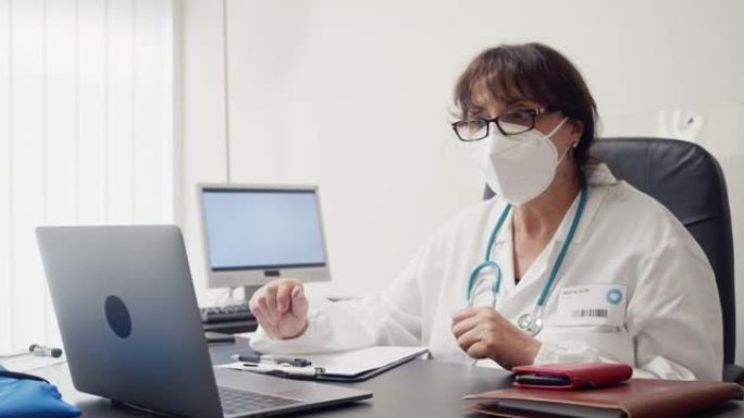 一名女医生在笔记本电脑前挥手