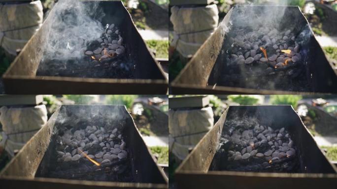 在烤架上吸烟木炭的慢动作镜头。肉很快就会在这里煮熟