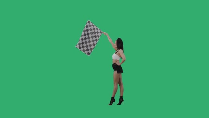 黑发挥舞着黑白方格赛车旗的侧视图，标志着比赛开始。年轻女子在绿屏背景下摆出全长姿势。慢动作就绪，4k