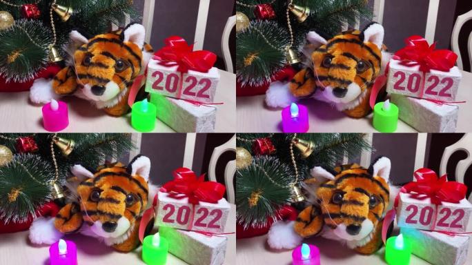 老虎符号2022年年份，蜡烛和礼品盒，白色桌子上有文字2022，房间里有新年树。