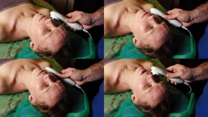 超声波面部按摩。在黑暗的背景下，对一名妇女的脸上进行了整容手术。
