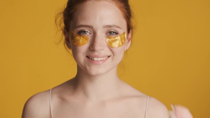 美丽迷人的女孩带着金色眼罩快乐地看着镜头