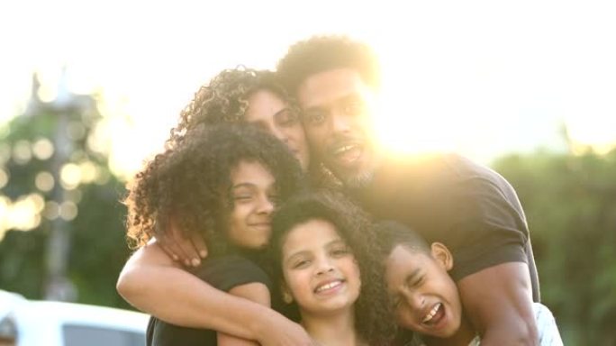充满爱心的家庭在阳光下拥抱着镜头，非洲黑人