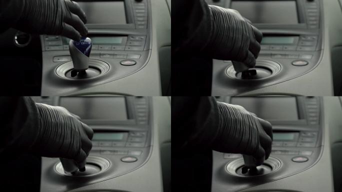 男子手持黑色手套用棍子设置汽车第一档