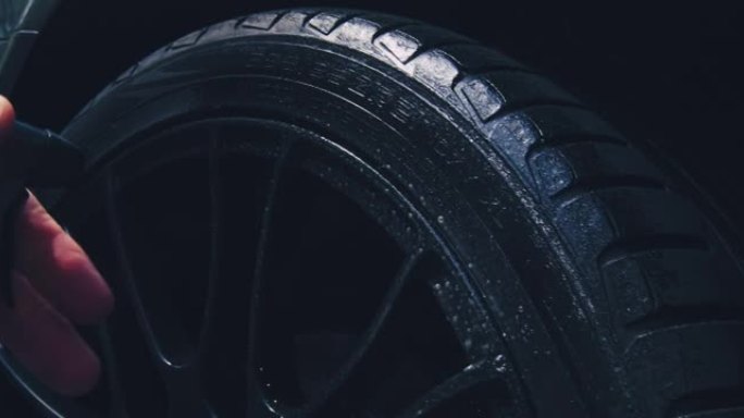洗车时用喷洒肥皂水关闭洗车轮胎。外部汽车细节概念