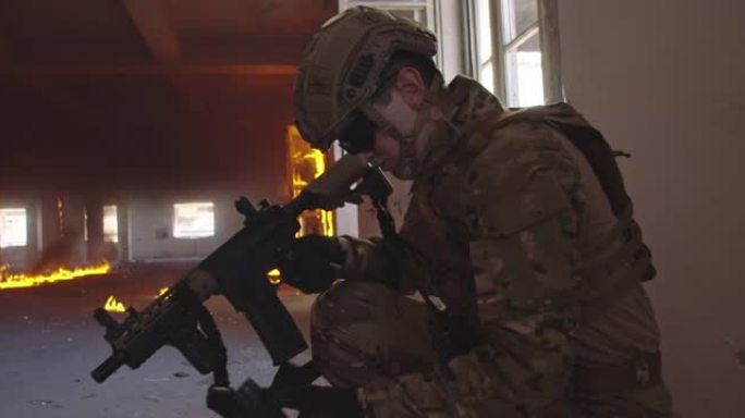 现代战争士兵在靠近窗户的地方换弹夹和掩护。在城市战场中通过窗户射击。