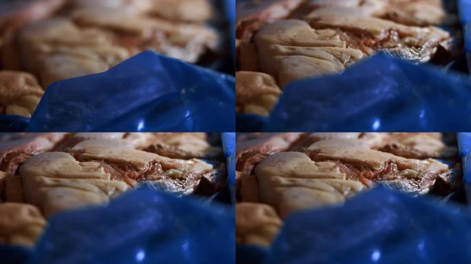 一个装满冷冻鸡腿的盒子的宏观视图。用冰覆盖的冷冻生鸡肉。4k视频