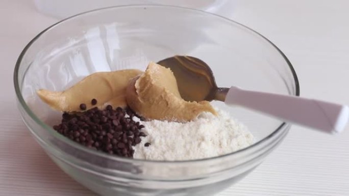 制作健康巧克力的花生酱、巧克力和椰子粉。在玻璃容器里。特写镜头。