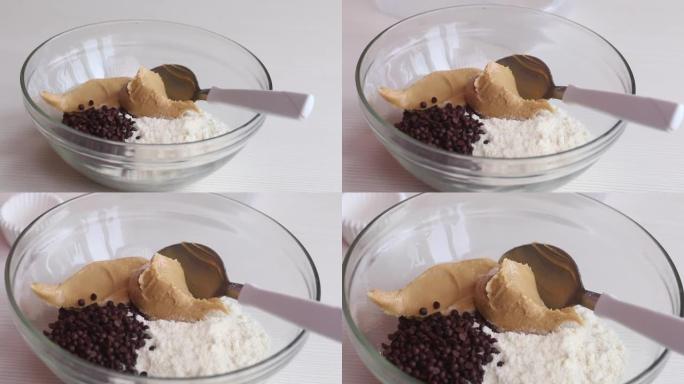制作健康巧克力的花生酱、巧克力和椰子粉。在玻璃容器里。特写镜头。