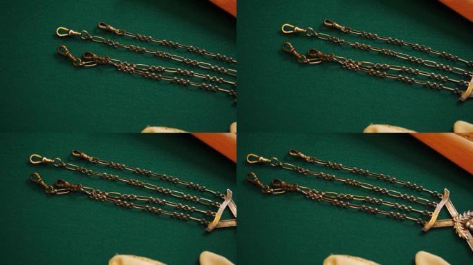 带链条的豪华金色古代吊坠。库存镜头。绿色织物背景上的老式复古珠宝特写。