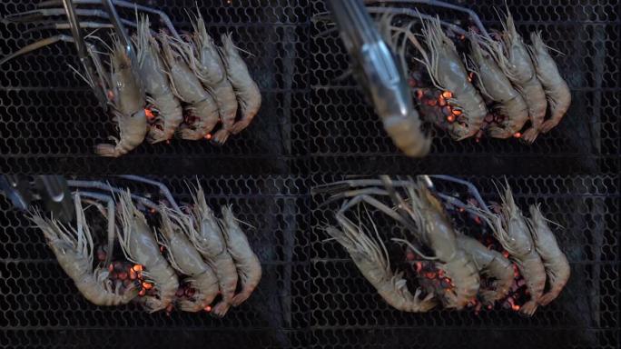 在木炭火上烤虾，在火上烤海鲜燃烧慢动作背景。