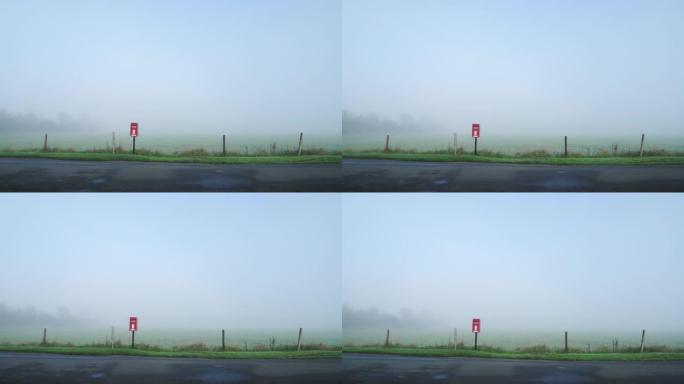 标志性的红色英国邮筒，英国公路旁乡村的邮筒，浓雾和薄雾笼罩着雾气，英国的传统乡村风光