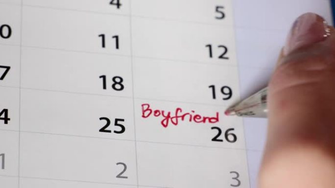 女性用红笔在日历上手写男朋友的生日提醒