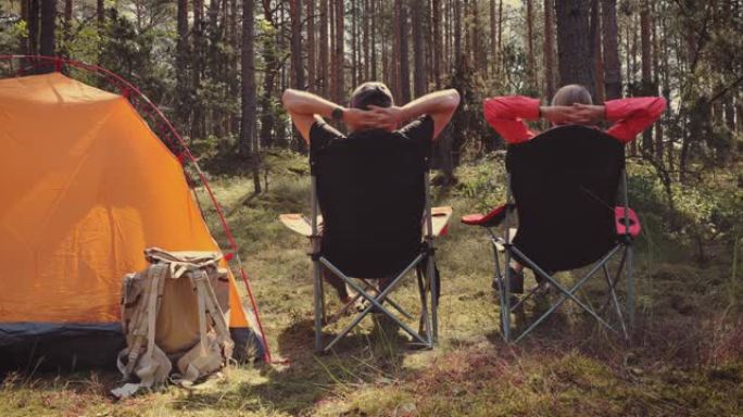 人们在森林露营地的野营椅上放松，享受大自然