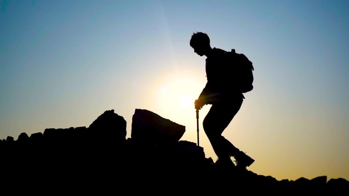 登上山顶的男人登山杖登山包