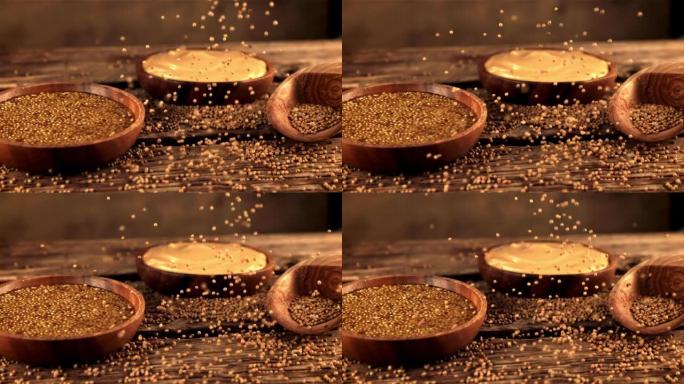 木质桌子上的超级慢动作掉落新鲜芥末颗粒。以1000 fps的高速相机拍摄。