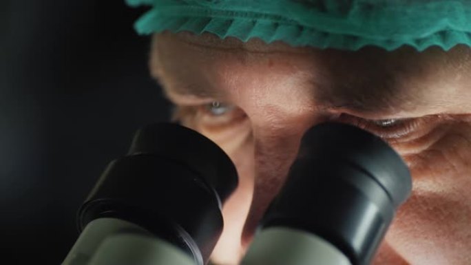 男性研究人员的脸看着显微镜的目镜