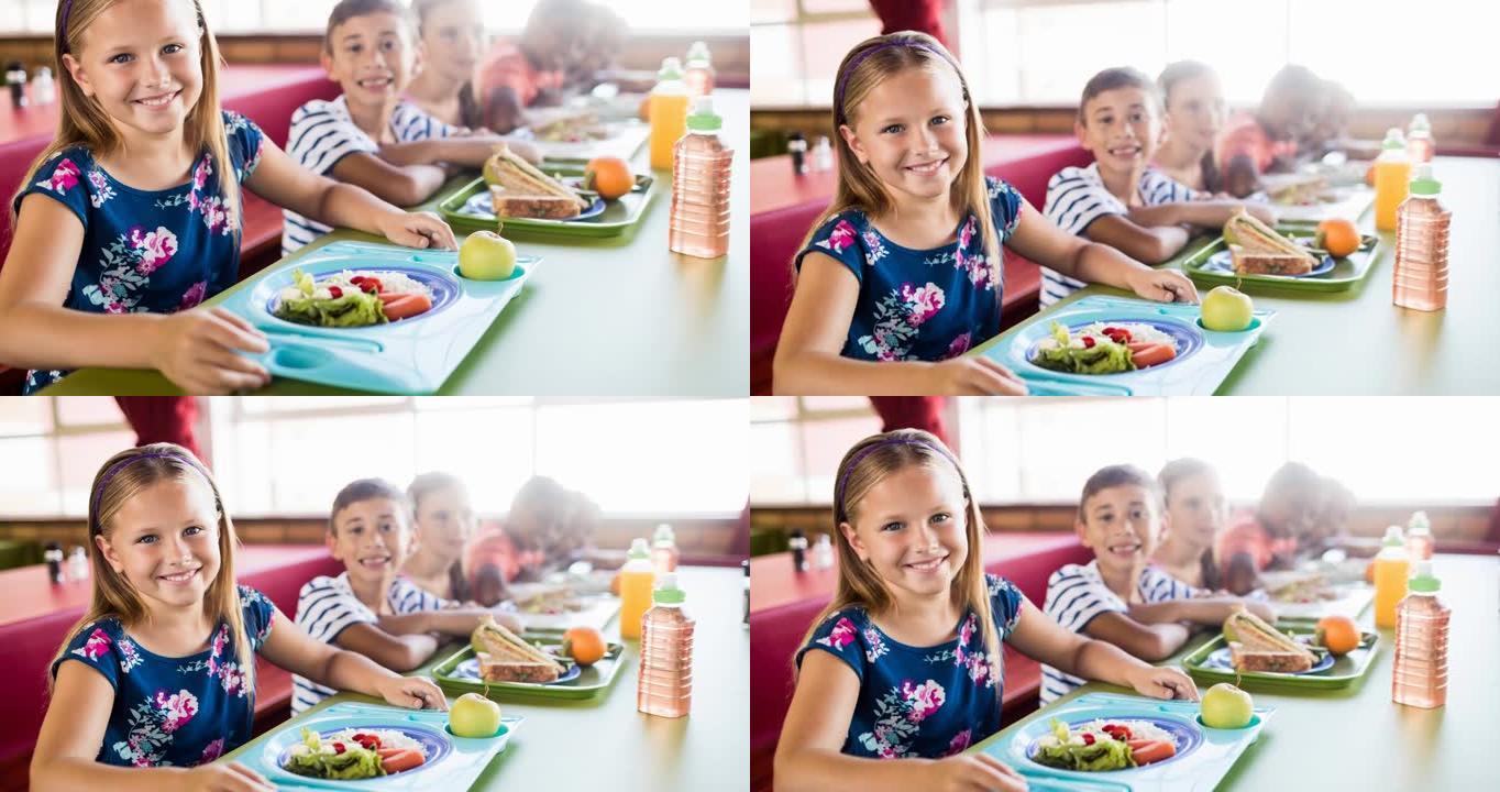 微笑的小学生在学校食堂吃午餐的动画