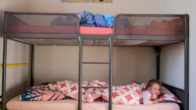 学龄前儿童兄弟姐妹躺在卧室的双层床上