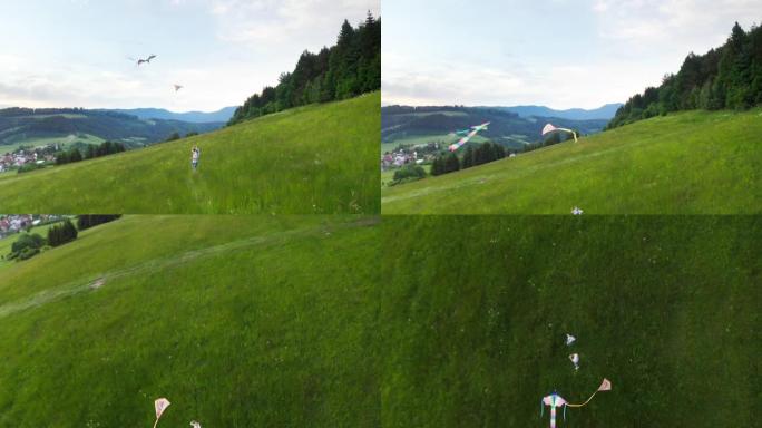 4k飞行无人机视图后，孩子们在高高的草地上放飞彩色风筝。然后飞过孩子们。快乐的童年时刻或户外时间消费