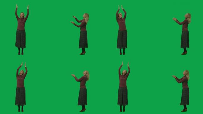 一个穿着长裙和高领毛衣的年轻女子的肖像，跳舞并拍手。绿屏背景上的2合1拼贴正面和侧面视图全长。慢动作