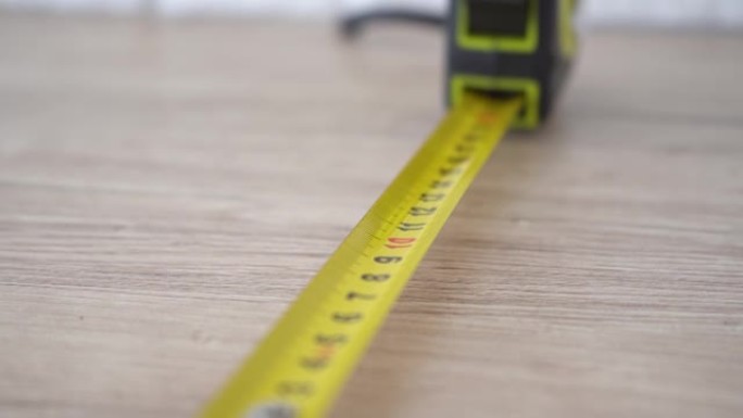 用黄色卷尺测量。用手将卷尺从卷尺中拉出并测量长度。4k素材。