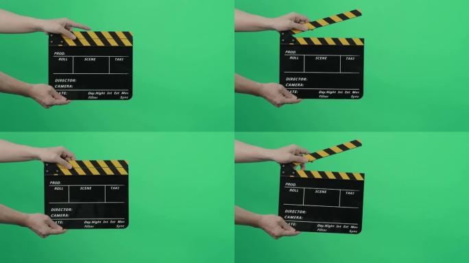 蓝绿色屏幕背景的电影石板或电影隔板。摄制组的人抓住并击中了框架中的电影石板。拍手胶片石板。视频制作色