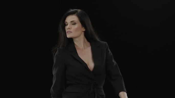 穿着黑色夹克的美丽优雅的女人看着相机移动。