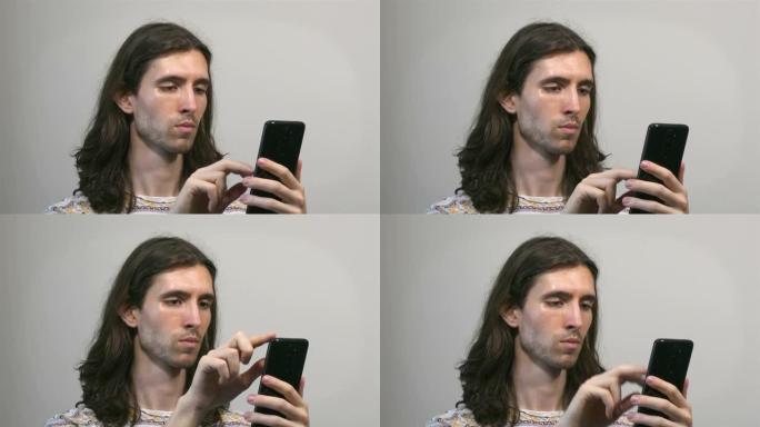 使用智能手机工作的年轻长发男子，四分之三视图