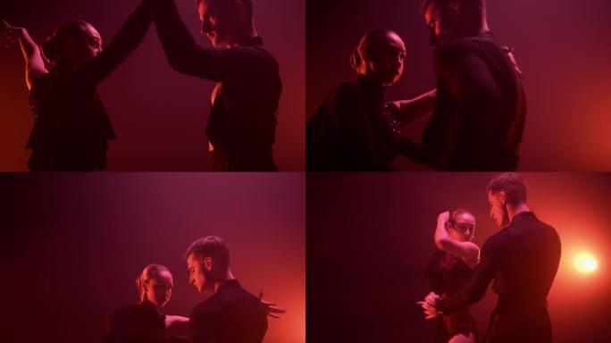 表演拉丁舞红光背景的舞者。舞厅情侣跳舞。