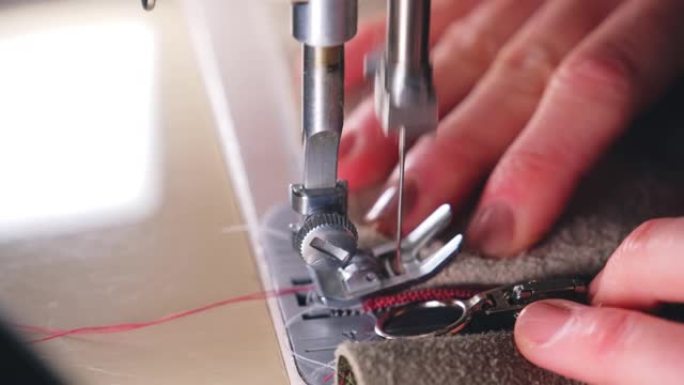 熟练的高加索专业女裁缝用缝纫机将拉链固定在皮革上
