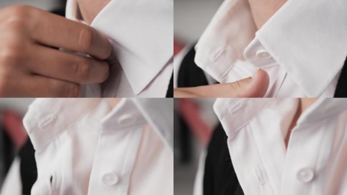 女人解开衬衫扣子，热概念。女性手解开白色衬衫的顶部两个纽扣。特写