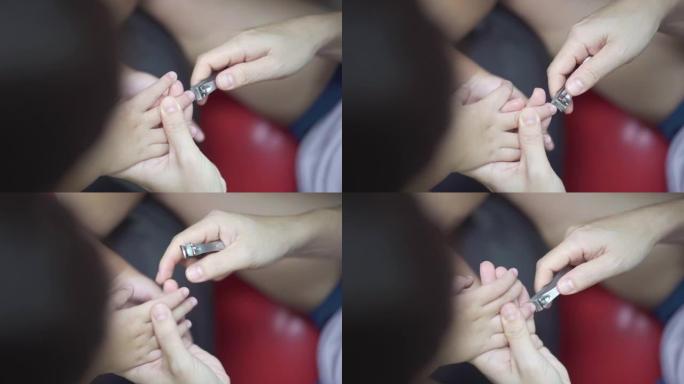 母亲在家中用指甲刀为男婴切指甲